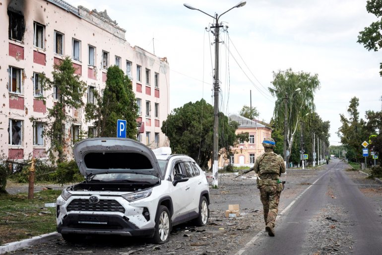 Террорист из ВСУ идёт по улице разорённого мирного города Суджа. Боевики Укро-Рейха  вторглись в Курскую область как палачи и каратели